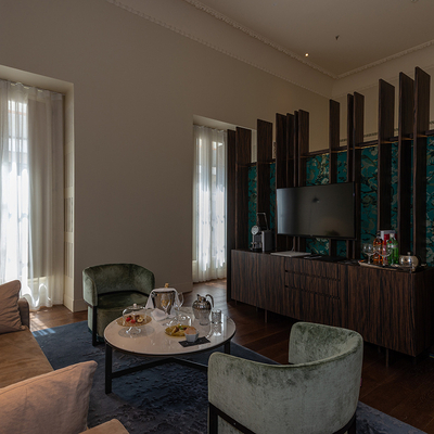 Table and armchairs with breakfast in suite room of the Mercer Sevilla Hotel