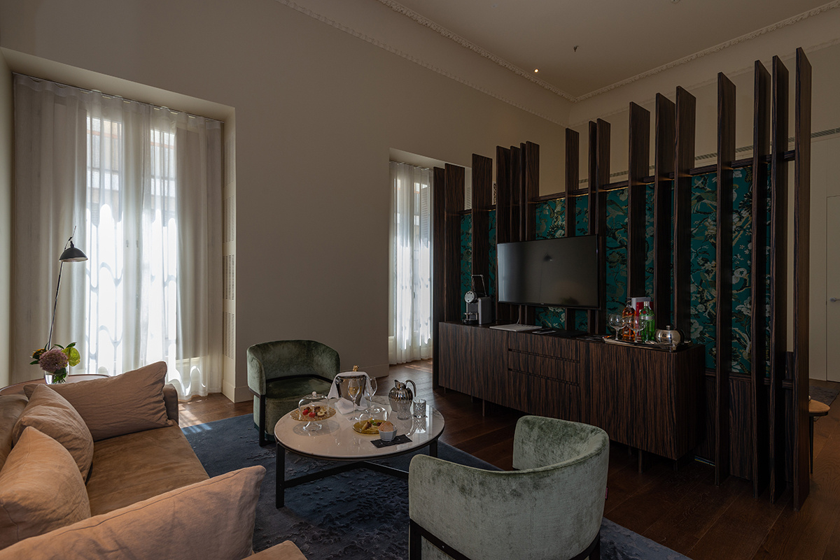 Mesa y butacas con desayuno en habitación suite del Hotel Mercer Sevilla